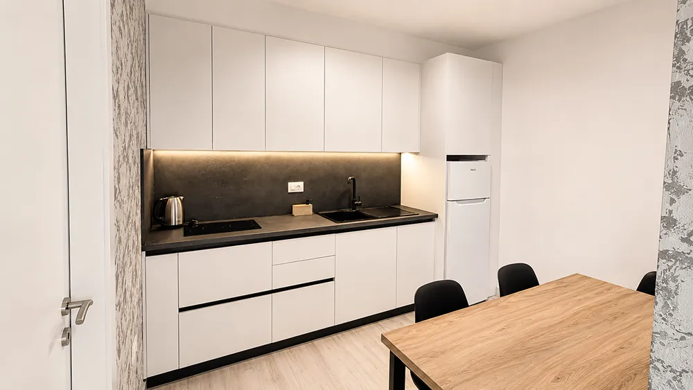 Moderní plně vybavená kuchyň v apartmánu s jídelním stolem